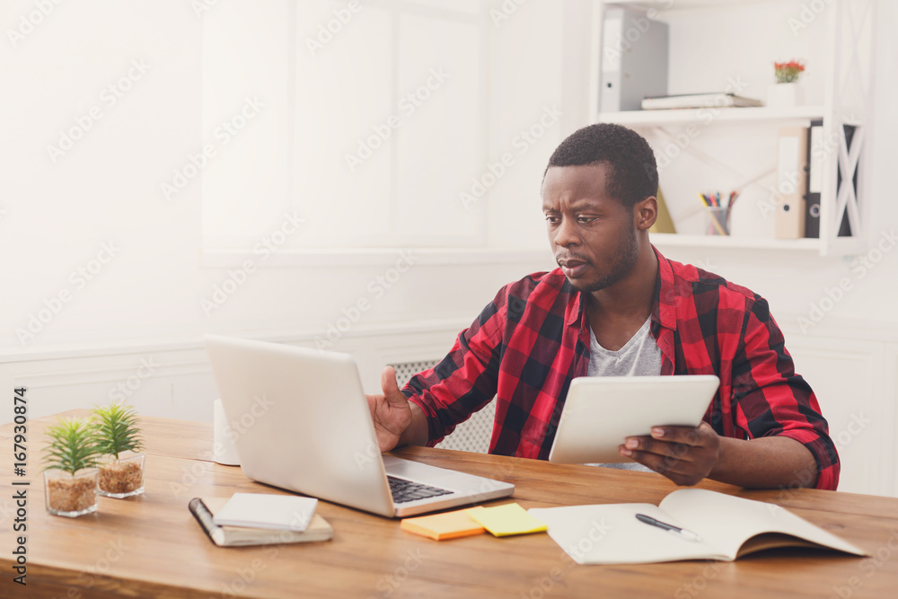 Pensive young black happy businessman in office, work with laptop Pensive young black happy businessman in office, work with laptop