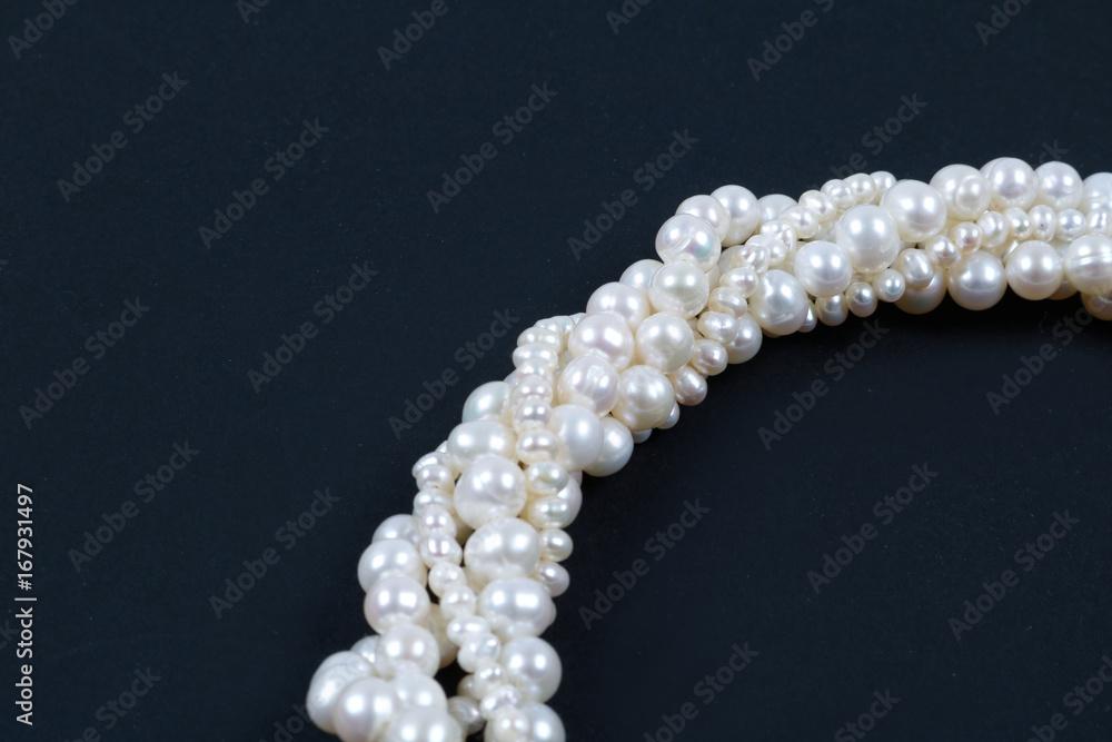 White pearl necklace on the dark background White pearl necklace on the dark background