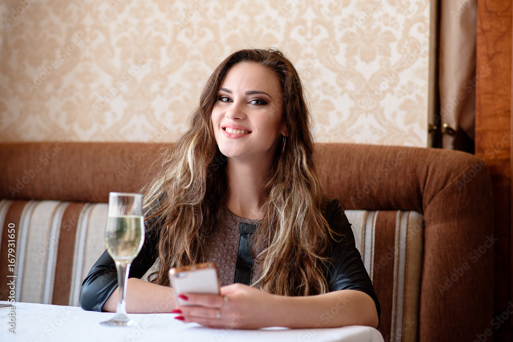 Beautiful girl with a phone at a table in the restaurant. Beautiful girl with a phone at a table in the restaurant.