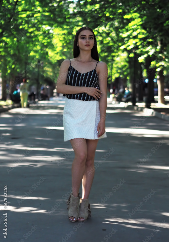 Young girl model posing at the park standing