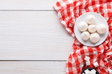 Sweet background. Meringues and sugar on white and red cloth on white wood