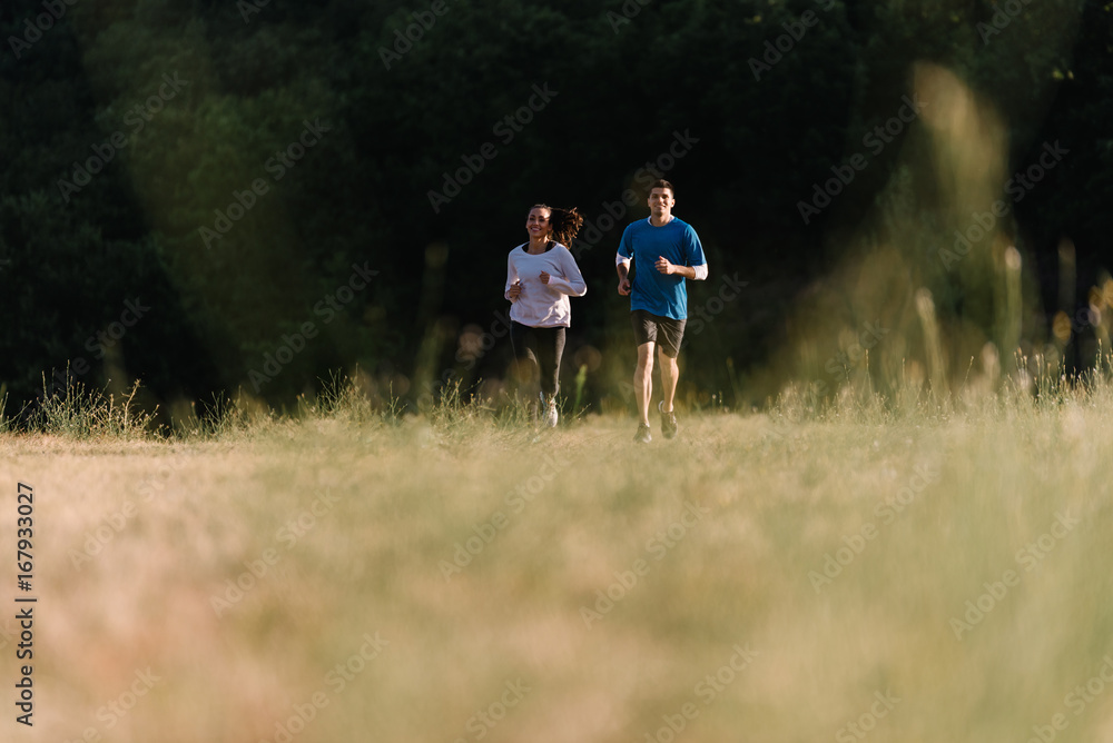 Fototapeta premium Couple running together on a field