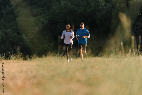 Young couple having fun racing each other on their daily jog
