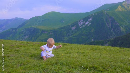 Wallpaper Mural baby is playing in the mountains, sitting and smiling Torontodigital.ca