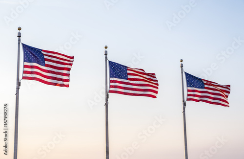 United States of America Flags Blowing in the Wind and Against the Blue Sky