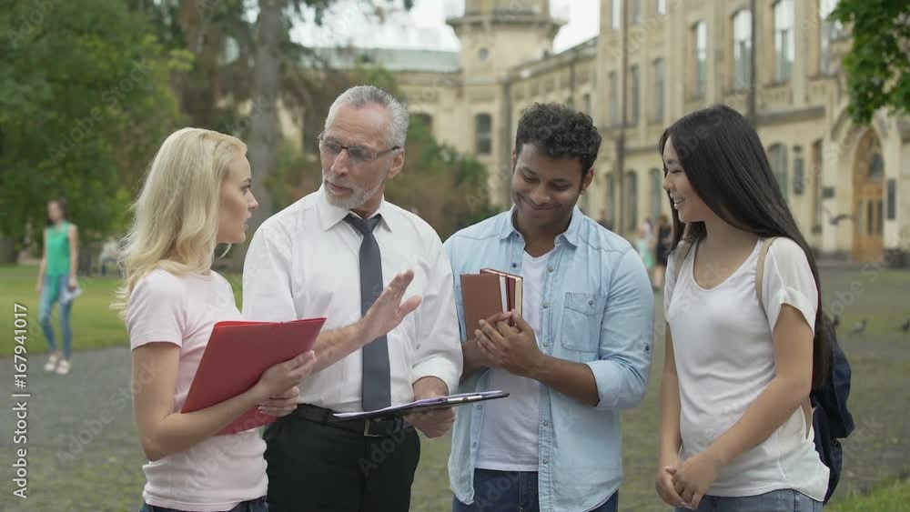 Physics teacher discussing results of scientific research with group of students Physics teacher discussing results of scientific research with group of students