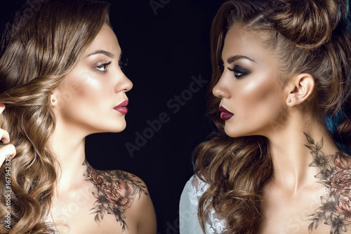 Close up portrait of two sides of the same woman with artistic make up, hairstyle and body art on her shoulder. One half symbolizes her good nature, another one is a dark side. Human nature conceptv photo