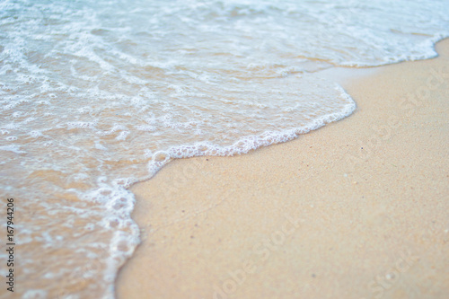 Fototapeta Naklejka Na Ścianę i Meble -  sea water waves with bubbles on sand beach