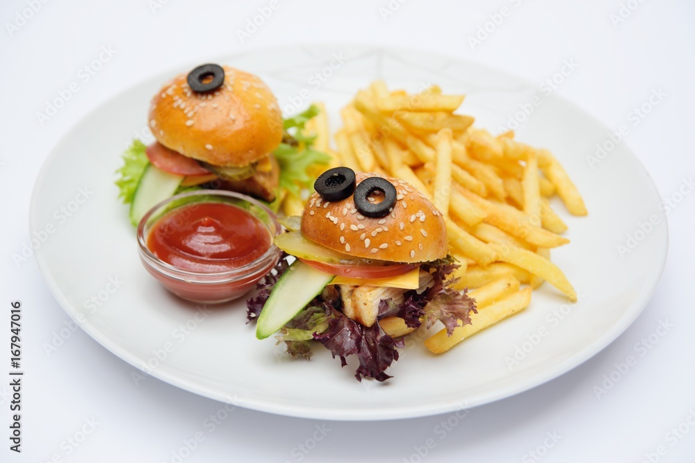 Funny baby burgers on a plate close-up with French fries and sauce