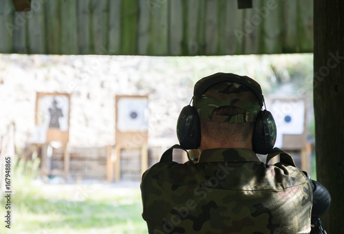 A man wearing ear protection training to the shooting competition at a firing range