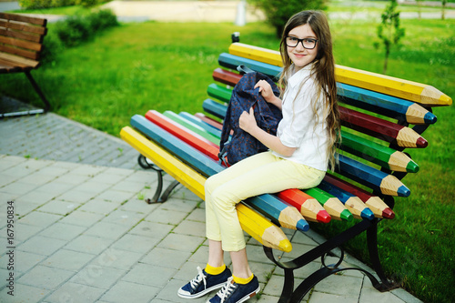 Kid girl doing homework in the park