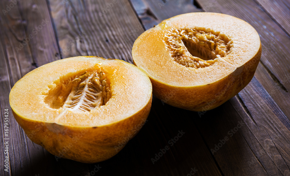 Melon cut in half on a wooden background