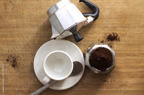 Italian moka with raw  minced coffe and a coffee cup