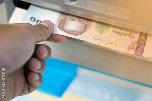 man receive money from the automated teller machine.people withdraw money from ATM and get it from money box or dispenser at cash point with light