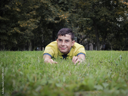 Smiling young man lying in the grass