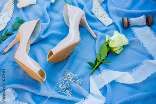 Fototapeta Naklejka Na Ścianę i Meble -  Wedding shoes. Footwear. Wedding accessories of the bride. Photo of a bride shoes on a blue background.