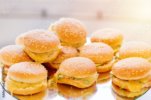 A lot of burgers in sun light in restaurant.
