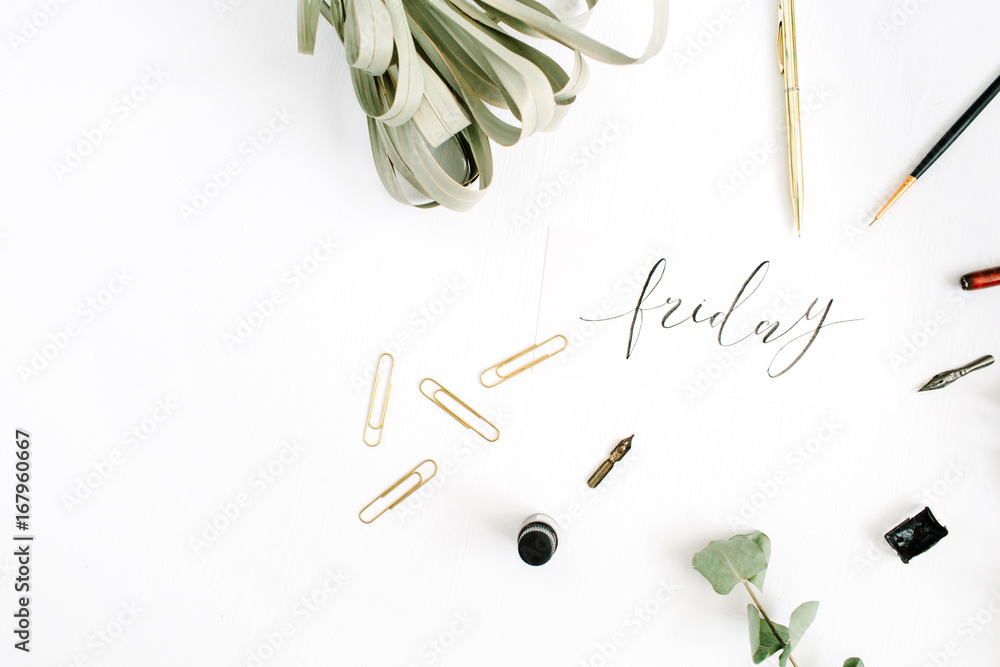 Word Friday written with calligraphy on white background with pen, brush, eucalyptus and clips. Flat lay, top view. Word Friday written with calligraphy on white background with pen, brush, eucalyptus and clips. Flat lay, top view.