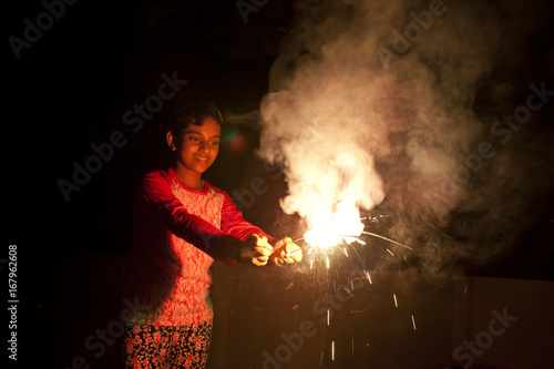 A teenage girl making fun with firecrackers photo