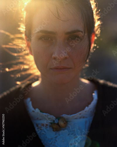 Portrait of a old fashioned lady wearing a traditional sardinian costume in the sunset light
