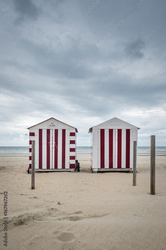 Two colorful beach cabins on a cloudy day in De Panne, Belgium. Two colorful beach cabins on a cloudy day in De Panne, Belgium.
