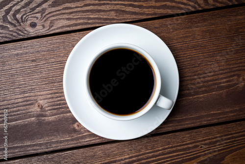 Cup of coffee on an old wooden table. Close up