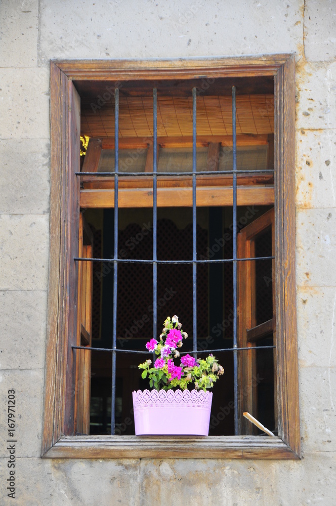 Flowers in pots on the balcony next to window