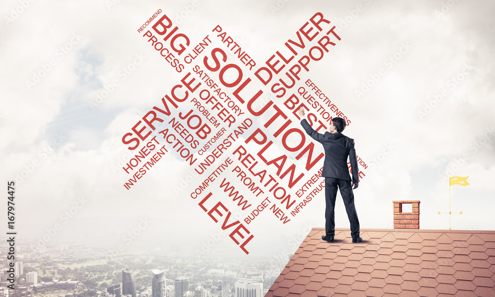 Young businessman standing on house roof and writing leadership Young businessman standing on house roof and writing leadership