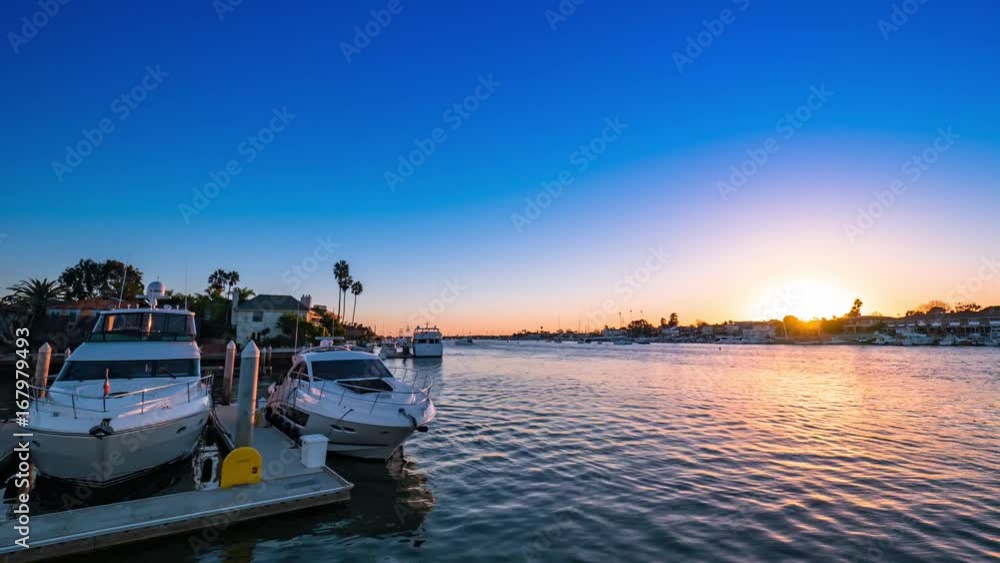 Cinematic timelapse shot at sunset over the harbor water in Newport Beach, California with boats, yachts and luxury real estate in view. Cinematic timelapse shot at sunset over the harbor water in Newport Beach, California with boats, yachts and luxury real estate in view.