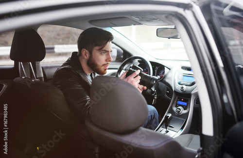 Εκτύπωση καμβά The man in the car reviews the photos on the camera