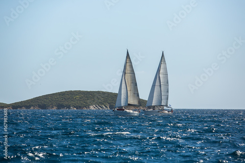 Sailing. Ship yachts with white sails in the open Sea. Luxury boats.