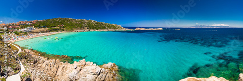 Spiaggia di Rena Bianca beach with red rocks and azure clear water, Sardinia, Italy
