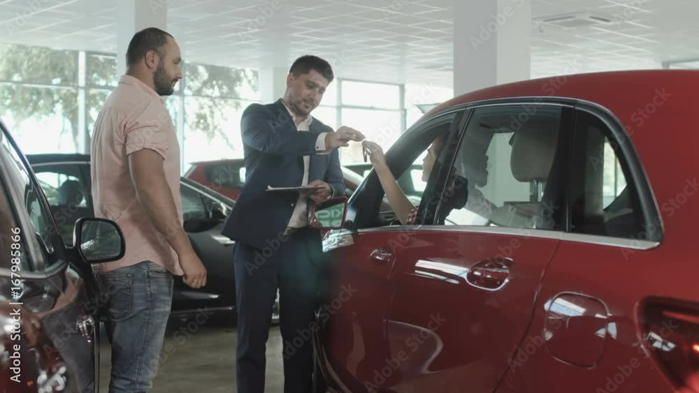 The couple buys a new car in car dealership The couple buys a new car in car dealership