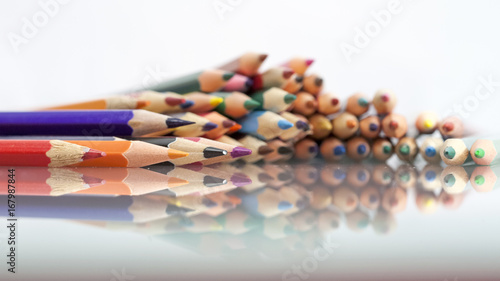 Group of sharp colored pencils with white background and reflexions 