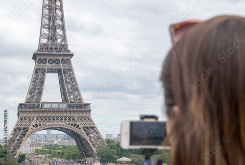 Tourist taking a picture of the Eiffel Tower in Paris © Jopstock