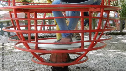 Enfants dans un parc sur un tourniquet rouge
