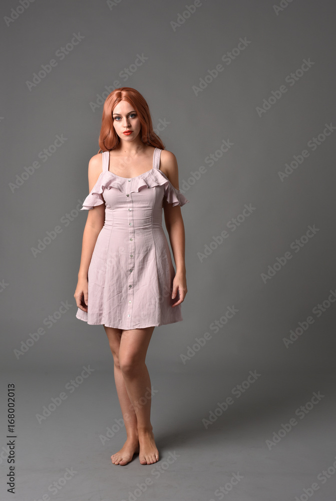 full length portrait of pr a pretty girl wearing simple purple dress, standing pose against a grey background full length portrait of pr a pretty girl wearing simple purple dress, standing pose against a grey background