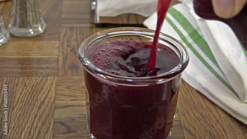 Pouring a glass of concord grape juice photo