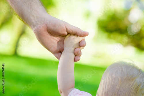 Baby girl holding father's hand © Ermolaev Alexandr