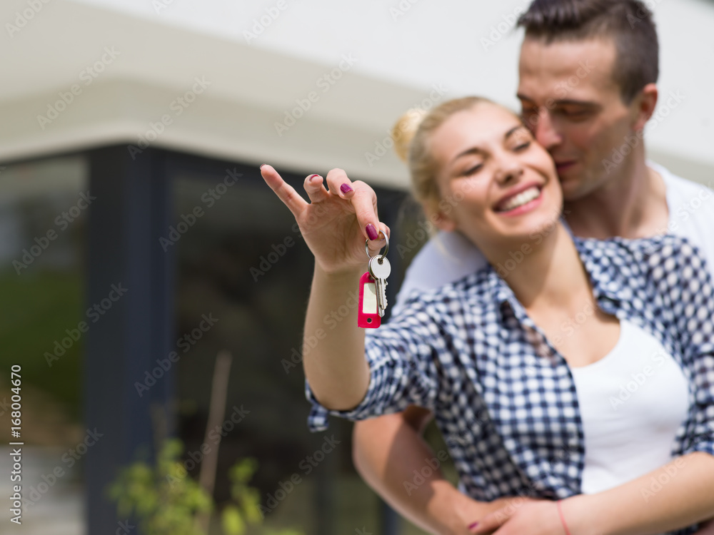 couple hugging in front of new luxury home couple hugging in front of new luxury home