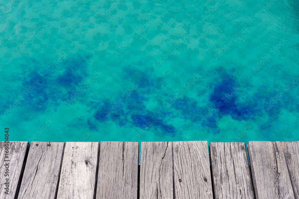 Blue liquid chlorine in green pool with wooden plank edge Blue liquid chlorine in green pool with wooden plank edge