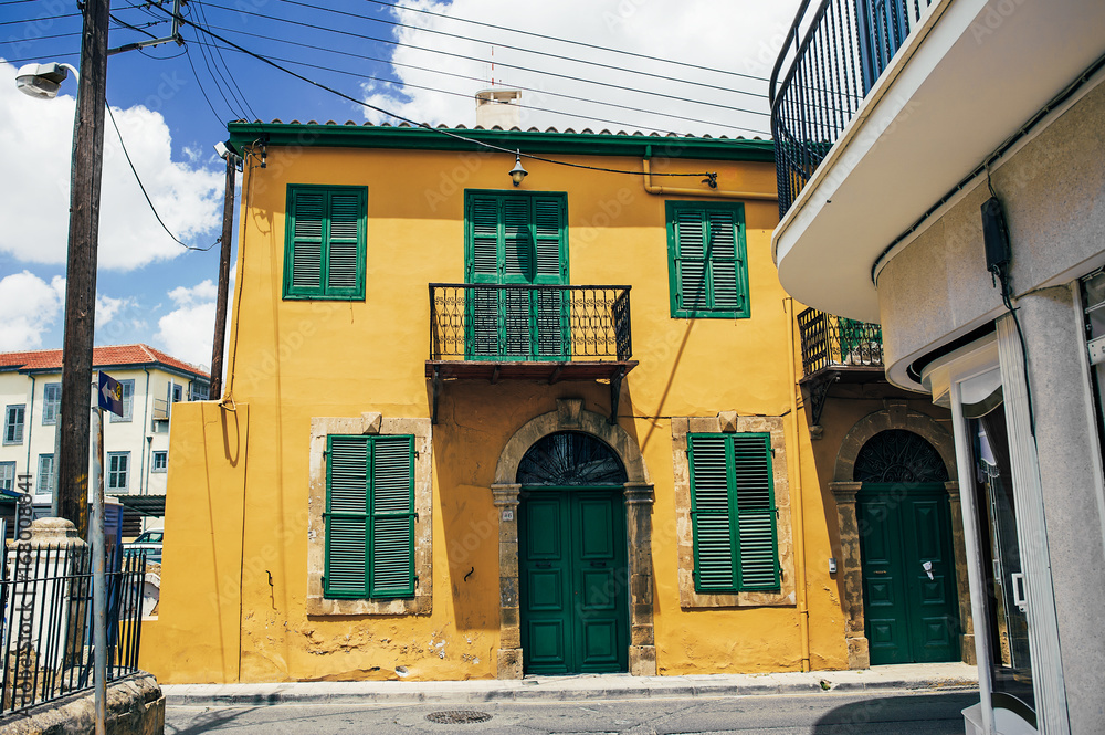 The old building. The shutters on the Windows. Beautiful building. northern Cyprus. Turkish Republic of Northern Cyprus. Yellow building with green Windows