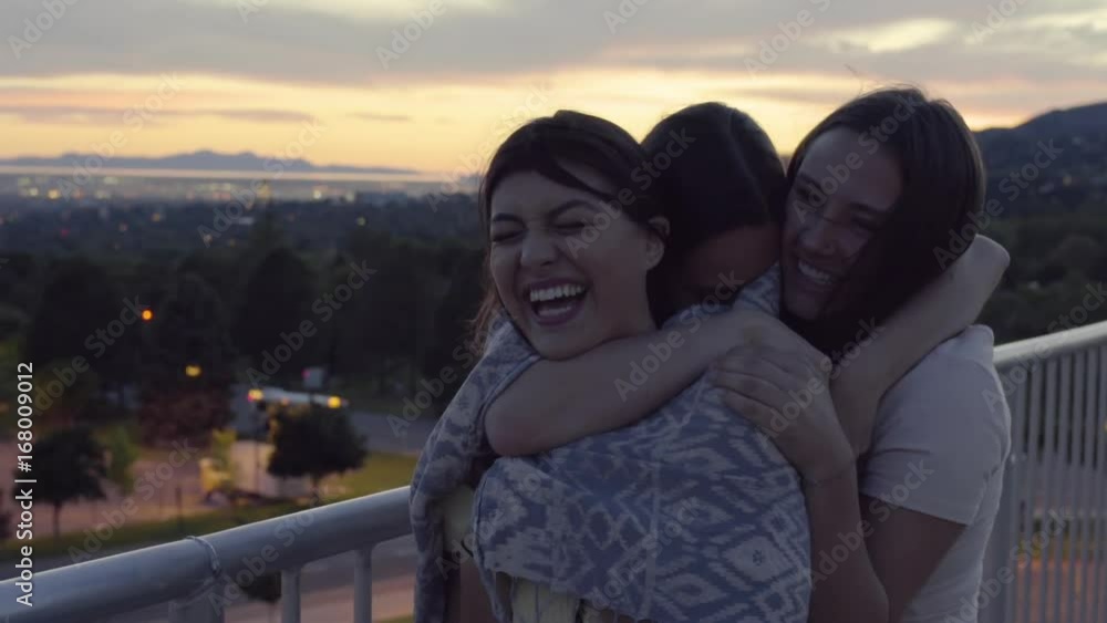 Happy Girls Have Group Hug And Laugh Really Hard At A Viewpoint, City And Mountains In Background Happy Girls Have Group Hug And Laugh Really Hard At A Viewpoint, City And Mountains In Background