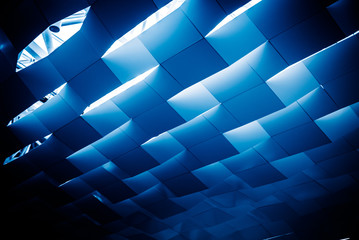 Low angle view of abstract building ceiling in blue tone.