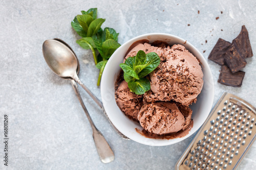 Chocolate ice cream with a bowl on a table. Ice cream  chocolate  cocoa  mint  grater. Summer dessert. Selective focus. Copy space. Flat lay.