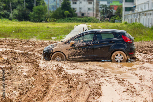 The black car stuck in the mud. Can not fall out of the mud photo