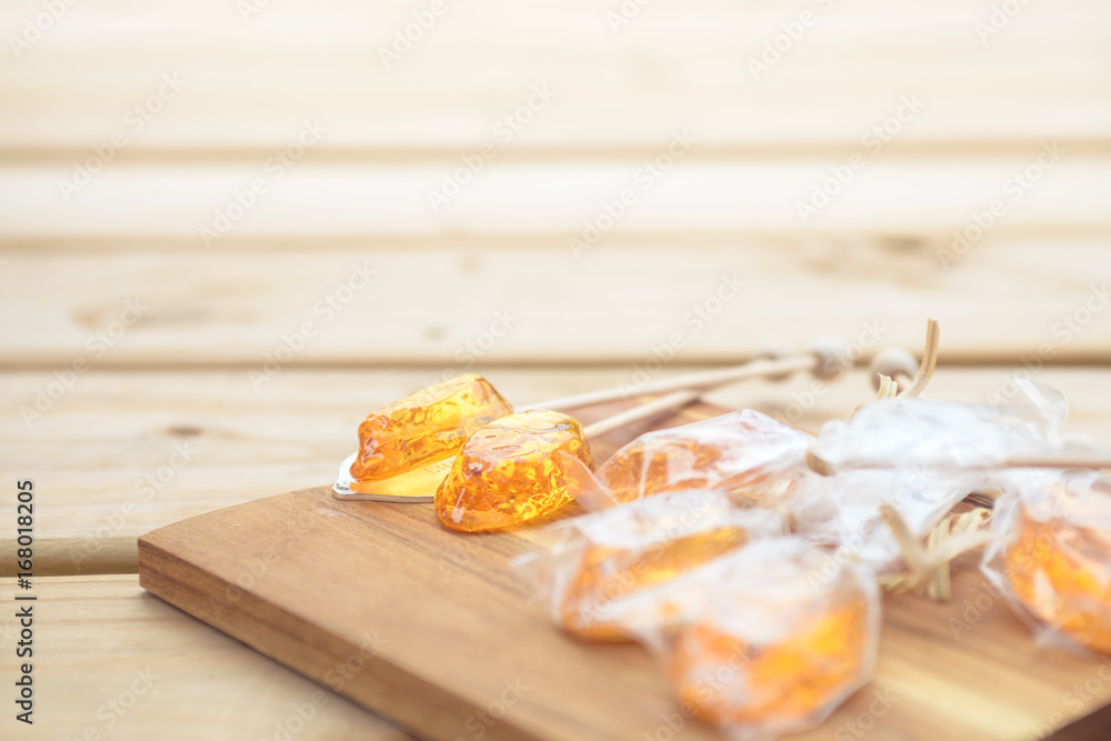 Honey caramel candy lollipop on wooden background