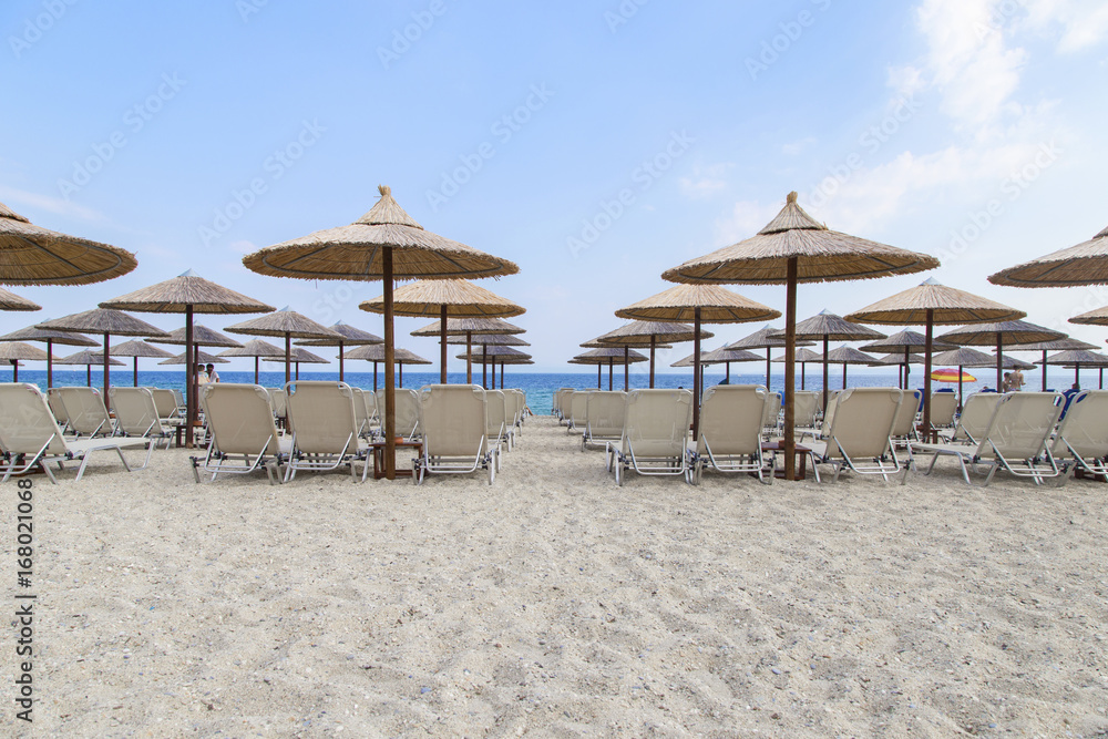 Sun umbrella and beach beds on tropical coastline Sun umbrella and beach beds on tropical coastline