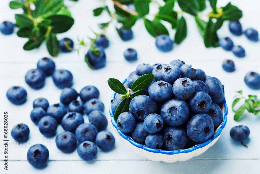 Blueberry or great bilberry in bowl on blue vintage table. Organic superfood and healthy nutrition. Blueberry or great bilberry in bowl on blue vintage table. Organic superfood and healthy nutrition.