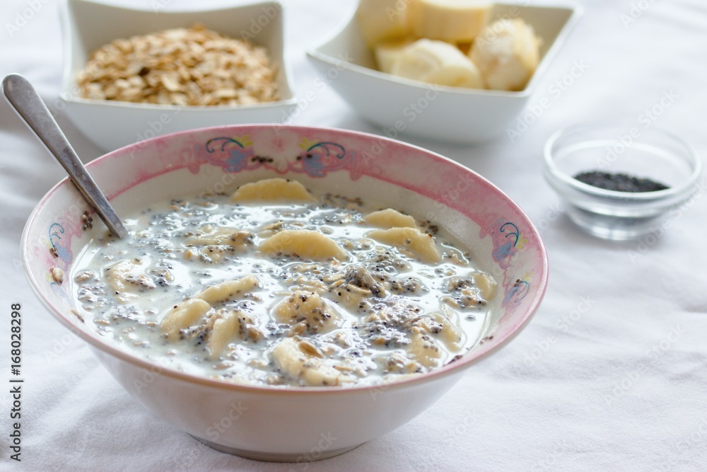 Breakfast dish of oatmeal, banana, milk and poppy seeds Breakfast dish of oatmeal, banana, milk and poppy seeds